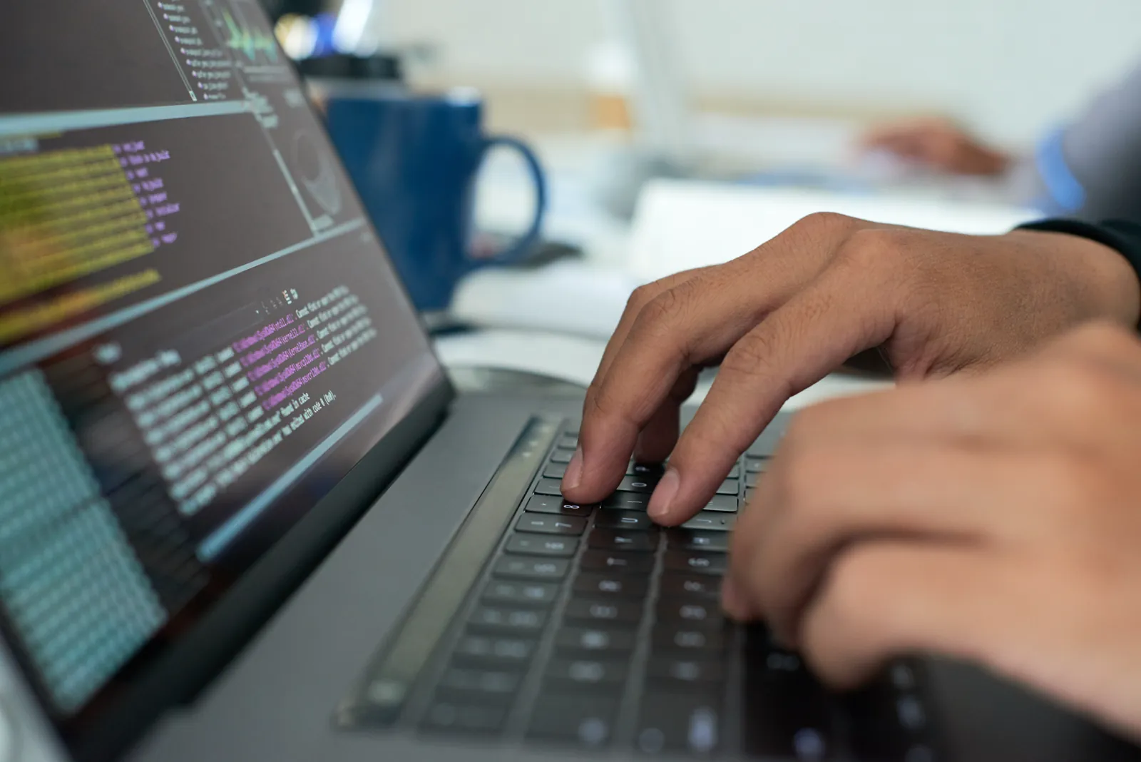 Workspace Althinia con monitor che mostrano codice e interfacce in sviluppo